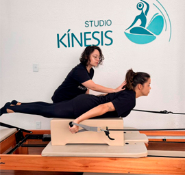 Mulher em posição de prancha lateral em reformer de Pilates com fundo branco
